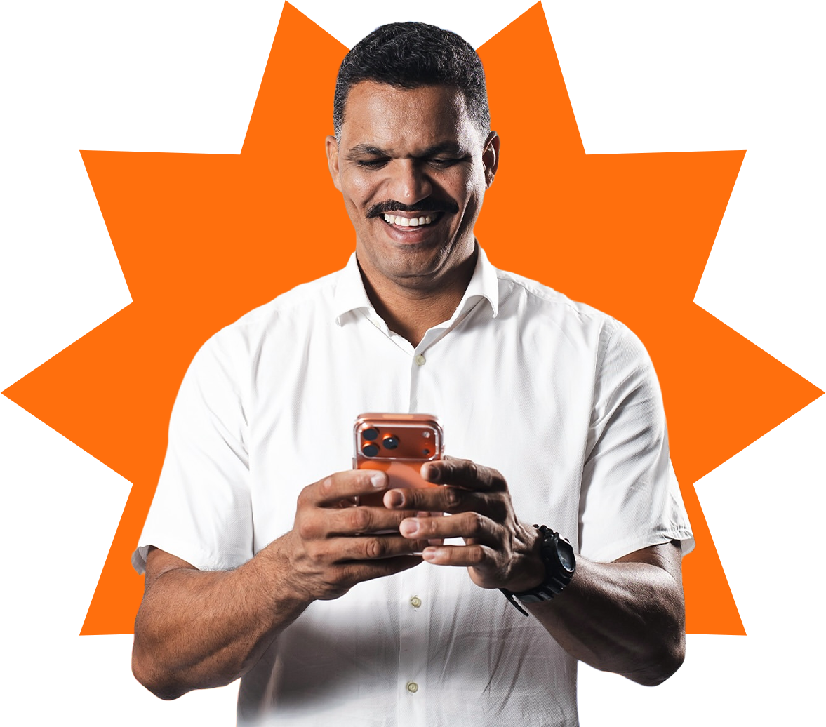 Bergue Júnior sorrindo enquanto usa o celular